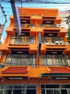 an orange building with windows and a red roof at Residence Inn Pattaya in Pattaya Central