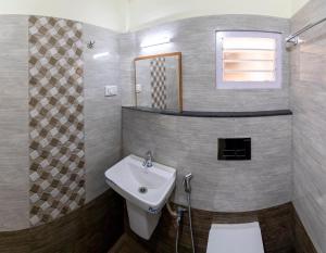 a bathroom with a sink and a toilet in it at La Smart Stays in Nāgercoil