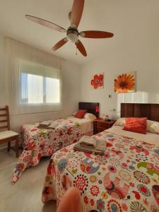 una camera con 2 letti e un ventilatore a soffitto di Apartamento en El Toyo a El Toyo