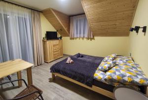 sypialnia z łóżkiem i drewnianym sufitem w obiekcie Wetlina Poza Trasą w Wetlinie