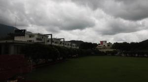 een groot groen veld voor sommige gebouwen bij GOLDEN LEAF RESORT in Surajgarha