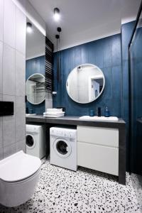 a bathroom with two washing machines and a sink and a toilet at Native Apartments Barska 69 in Krakow
