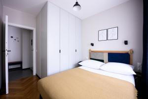 a bedroom with a large bed with white walls at Native Apartments Barska 69 in Krakow