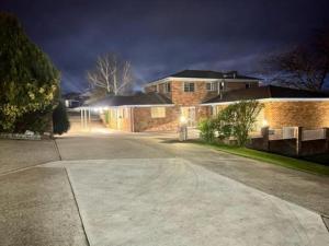 a driveway in front of a house at night at Kinross Inn in Cooma
