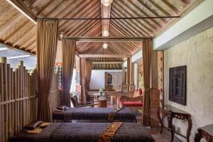 una camera con tre letti in una stanza con di Kailash Suites by Pramana Villas ad Ubud