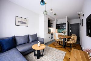 a living room with a blue couch and a table at Native Apartments Barska 69 in Krakow
