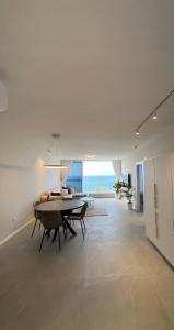 a dining room with a table and a view of the ocean at Vacation Apartment By The Beach in Bat Yam