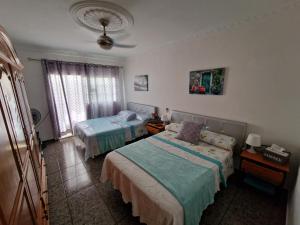 una camera con due letti e una finestra di Apartment & Beach breakfast free a Playa del Burrero
