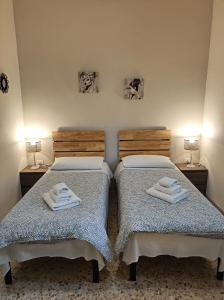 - 2 lits dans une chambre avec des serviettes dans l'établissement ZEUS, à Monopoli