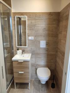 a bathroom with a toilet and a sink and a mirror at ZEUS in Monopoli