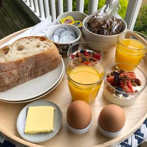 a table with a breakfast of bread and eggs and food at Skippers Apollo Bay in Apollo Bay