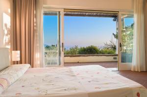 a bedroom with a large bed and a large window at Borgo La Pietraia in Paestum