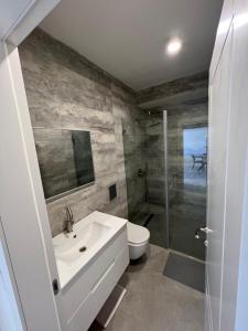 a bathroom with a sink and a toilet and a shower at Vacation Apartment By The Beach in Bat Yam