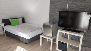 a small room with a bed and a flat screen tv at Gästehaus Yvonne Sigg in Rust