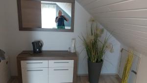 a woman taking a picture of a mirror in a room at Gästehaus Yvonne Sigg in Rust