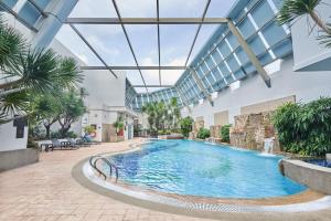 a swimming pool in a building with a glass ceiling at Adina Serviced Apartments Singapore Orchard in Singapore