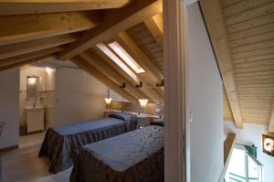 1 dormitorio con 2 camas en una habitación con techos de madera en Cadifiore B&B, en Mira