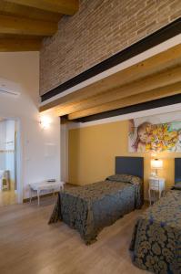 una habitación de hotel con 2 camas y un cuadro en la pared en Cadifiore B&B, en Mira