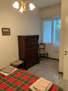 モネーリアにあるCasa Bianca 4 - confortevole in centro a Monegliaのベッドとドレッサーと窓のある寝室