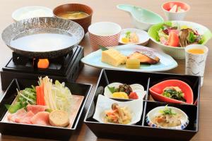 una mesa cubierta con diferentes tipos de comida en bandejas en Marukyoo, en Nikko