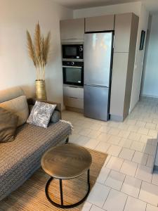 a living room with a couch and a refrigerator at VUE SUPERBE SUR LA GRANDE BLEUE in Canet-en-Roussillon