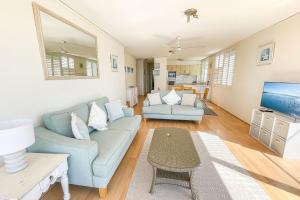 a living room with a couch and a tv at Harbourside 13 fantastic waterfront unit in Soldiers Point