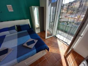 1 dormitorio con 1 cama azul y blanca y balcón en Celtic House B&B, en Varazze