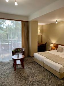 スタロザゴルスキー・バニにあるSpa Hotel Calistaのベッド、椅子、テーブルが備わるホテルルームです。