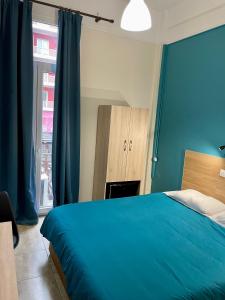 فندق كاستوريا في سلانيك: غرفة نوم زرقاء مع سرير ونافذة