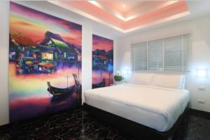 a bedroom with a bed and a painting on the wall at PATONG TOWER FAMILY SEA VIEW by PTA in Patong Beach