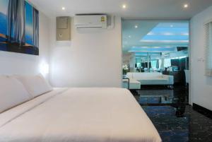 1 dormitorio con 1 cama blanca y sala de estar en PATONG TOWER FAMILY SEA VIEW by PTA en Patong Beach