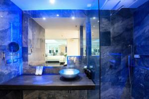 a blue bathroom with a sink and a mirror at PATONG TOWER SEA VIEW for FAMILY's by PATONG TOWER AGENCY in Patong Beach