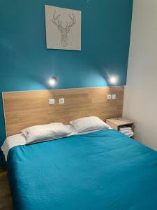 a bedroom with a blue bed with a wooden headboard at Hotel Kastoria in Thessaloniki