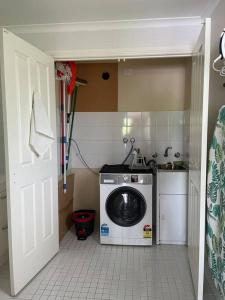 eine Küche mit Waschmaschine in einem kleinen Zimmer in der Unterkunft Violet Cottage in the City in Hobart