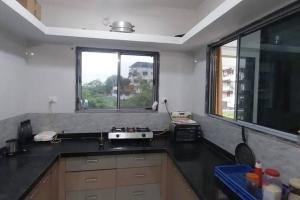 a kitchen with a black counter top and a window at AG House Daman holiday Home apartment in Daman