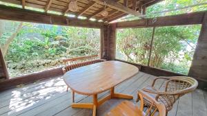 un tavolo e sedie in legno su una veranda riparata di 「池間島の一棟貸切りの宿アロハナ」日本最大級のサンゴ礁群ヤビジに最も近い宿。夕陽,海まで徒歩3分 a Miyakojima