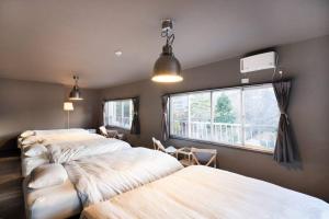 山中湖的住宿－tj resort YAMANAKAKO Luxury large villa with Mt. Fuji, Sauna BBQ Max 25，一间卧室设有两张床和窗户。
