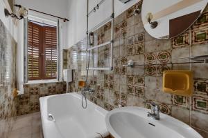 Beach rooms Riviera - Žuta Kuća في ماكارسكا: حمام مع حوض ومرحاض ومرآة