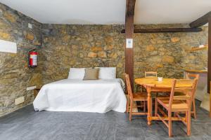 una camera con letto e tavolo in legno di Precioso piso estilo rústico a 10 min de Santander a Camargo