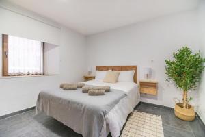 a white bedroom with a large bed with two pillows at Precioso piso estilo rústico a 10 min de Santander in Camargo