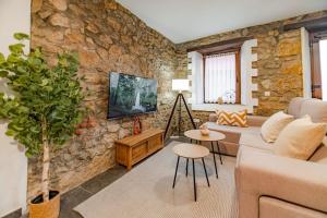 a living room with a stone wall at Precioso piso estilo rústico a 10 min de Santander in Camargo