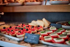 una vitrina con muchos tipos diferentes de alimentos en Hotel GIO en Múnich