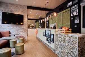 a restaurant with a bar with stools and a brick wall at Hotel GIO in Munich +46 photos