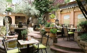 a patio with tables and chairs and a fountain at Hotel GIO in Munich