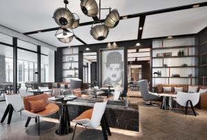 a lobby with chairs and tables and a large window at Qingdao Oriental Studio Chuangzhi SSAW Hotel in Qingdao