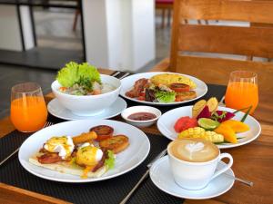 een tafel met borden ontbijtproducten en een kopje koffie bij Sala Siem Reap Hotel in Siem Reap