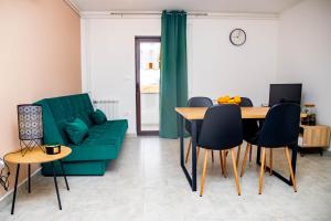 a living room with a green couch and a table at Apartment Fioretti in Bale