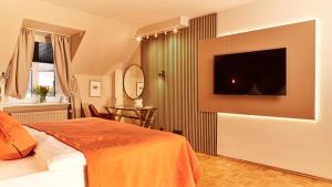 ein Schlafzimmer mit einem Bett und einem Fernseher an der Wand in der Unterkunft Hotel van Bebber in Xanten + 33 Fotos