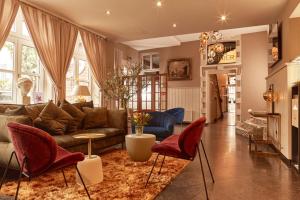 Hotel van Bebber في إكسانتن: غرفة معيشة مع أريكة وكراسي حمراء
