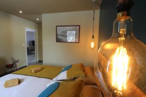 a bedroom with a bed and a large glass bottle at Maison le Pré de Paul in Saint-Savin